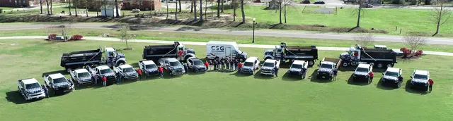 Aerial view of the Construction Services Group team with its trucks and work vehicles lined up on a lawn